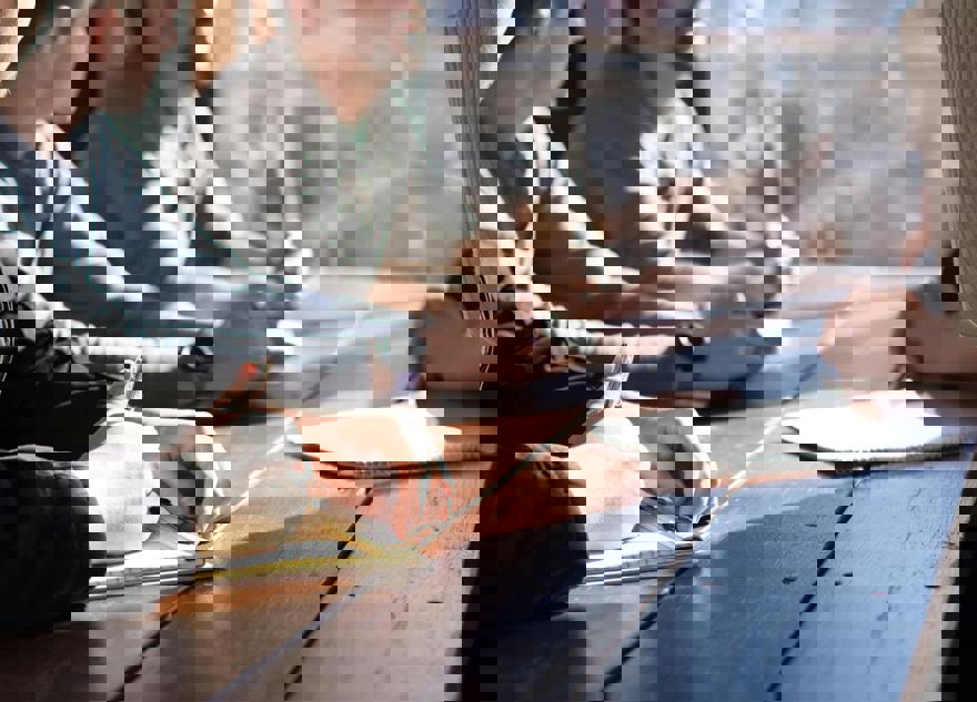 Personer sidder ved et bord og tager notater